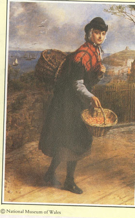 Llangwm Fisherwoman posing in traditional costume with Tenby harbour in the background